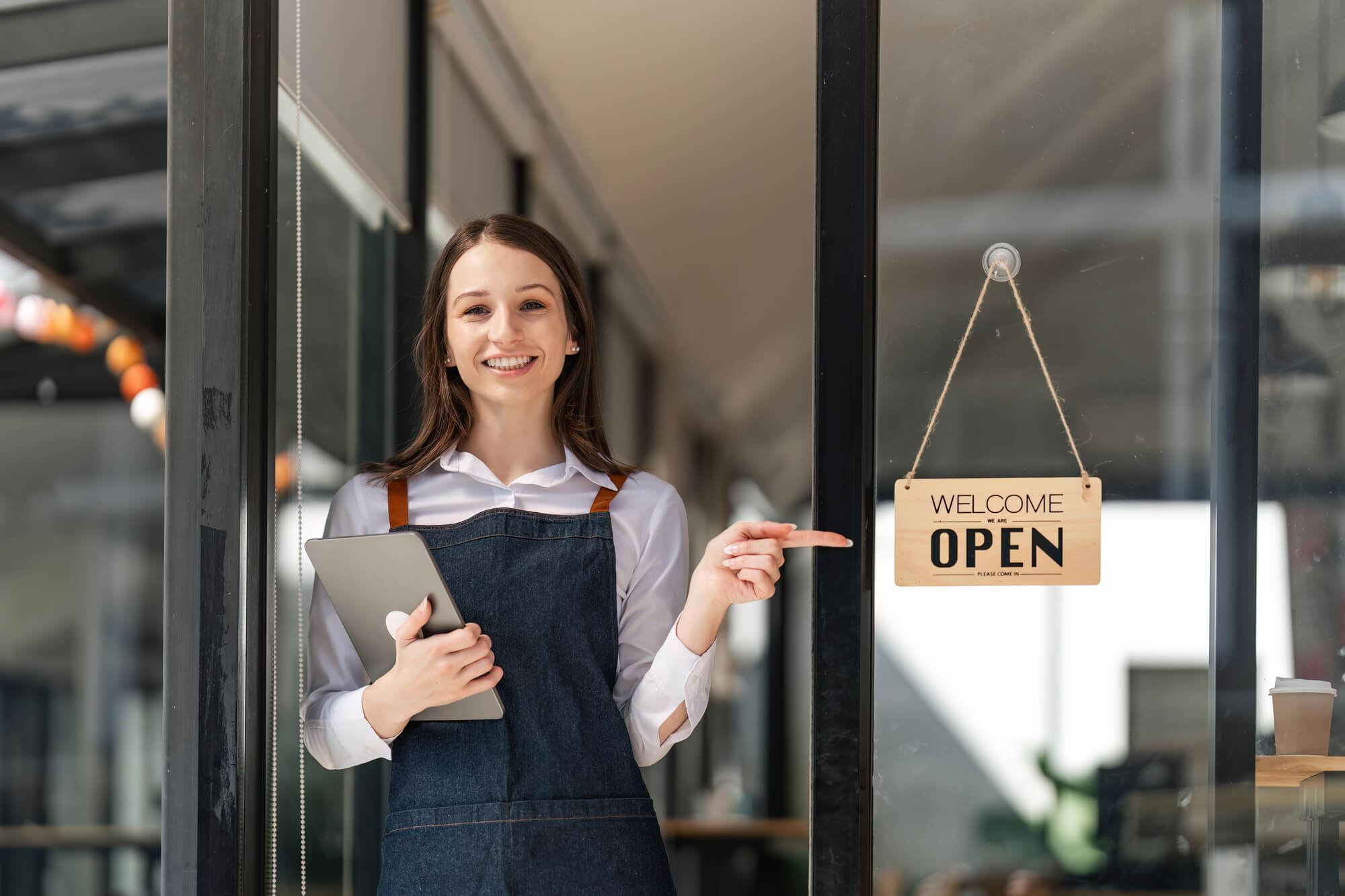 woman pointing at open sign